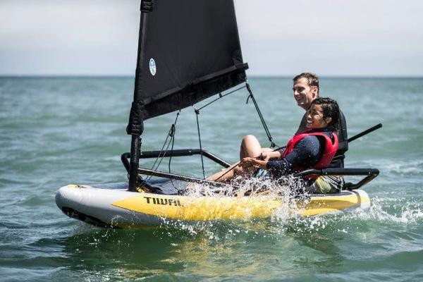 Slide: The Image of Two people sailing a 2022 Tiwal 3 sailboat on the ocean. - 0