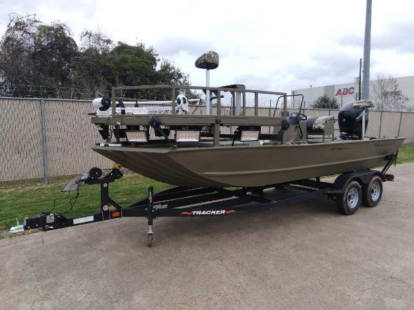 Slide: The Image of 2024 Tracker Grizzly 2072 CC Sportsman boat on trailer in outdoor setting. - 1
