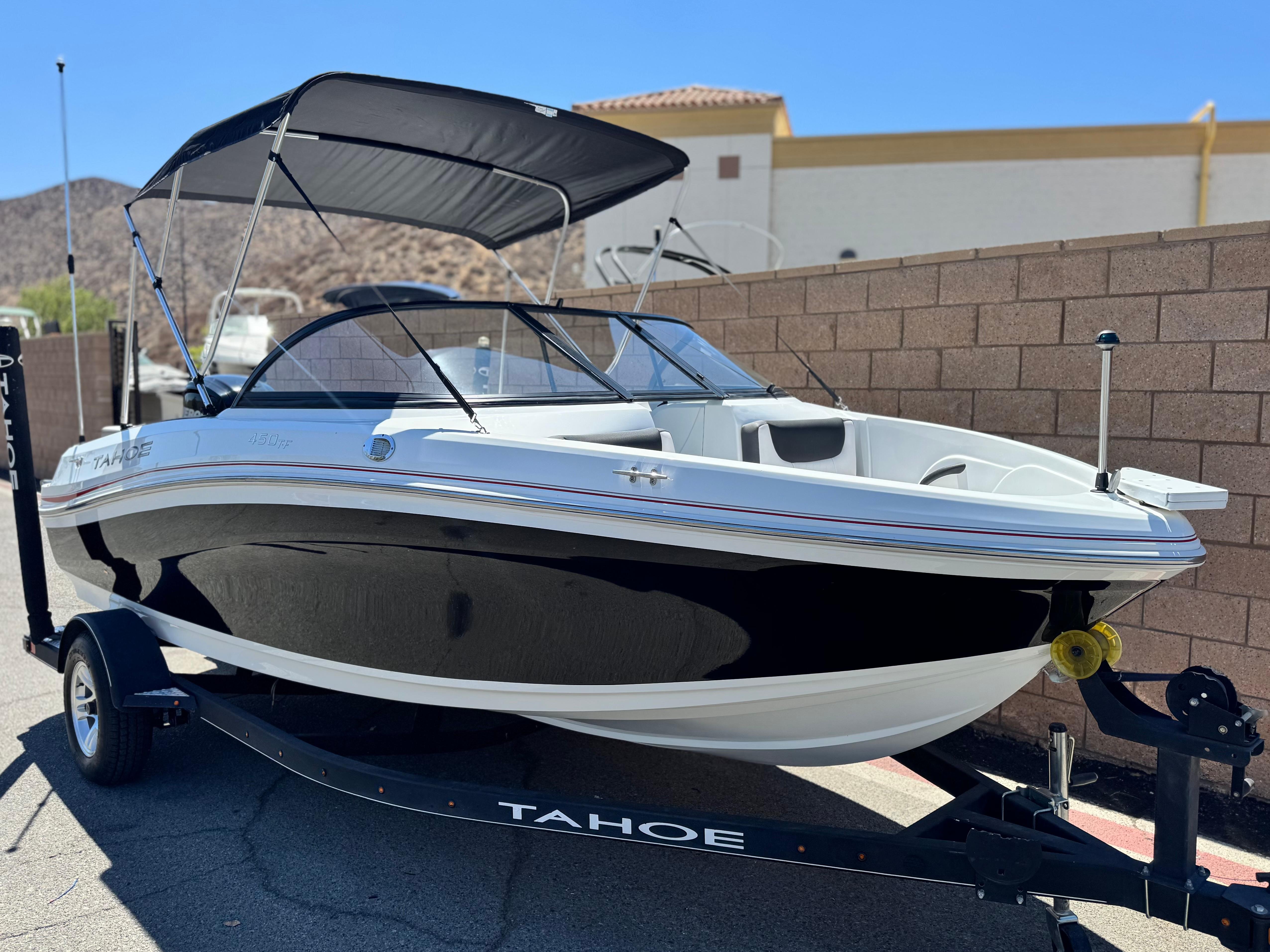Slide: The Image of 2019 Tracker Tahoe 450 TF boat on trailer, parked outdoors with bimini top. - 1