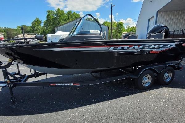 Slide: The Image of 2024 Tracker Targa V-19 WT boat on trailer, black exterior, parked outdoors. - 0