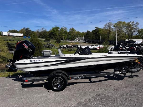 Slide: The Image of 2023 Triton 179 TrX boat on a trailer in a parking lot. - 2
