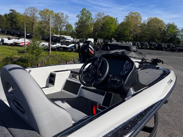 Slide: The Image of 2023 Triton 179 TrX boat with steering console and seating, parked outdoors. - 3