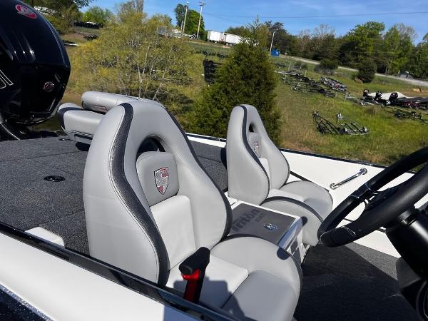 Slide: The Image of 2023 Triton 179 TrX boat interior with gray seats and steering wheel. - 4