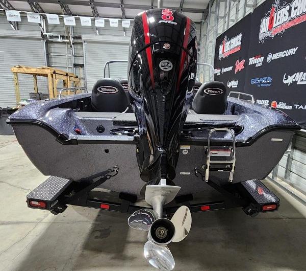 Slide: The Image of 2024 Triton 186 Allure boat in showroom, rear view with outboard motor. - 11