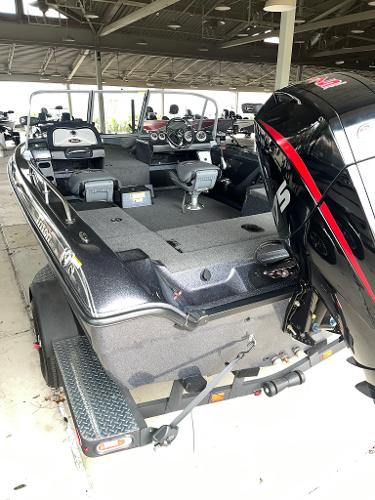 Slide: The Image of 2023 Triton 186 Fishunter boat with powerful outboard motor in showroom. - 2