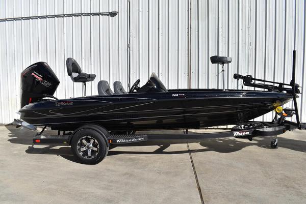 Slide: The Image of 2024 Triton 18 TrX bass boat on trailer, black exterior, side view. - 0