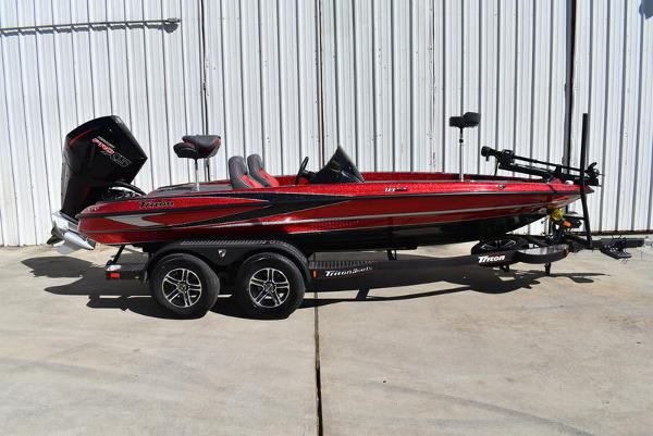 Slide: The Image of 2024 Triton 18 TrX bass boat on trailer, red and black. - 0
