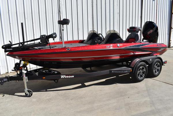 Slide: The Image of 2024 Triton 18 TrX bass boat in red and black on a trailer. - 1