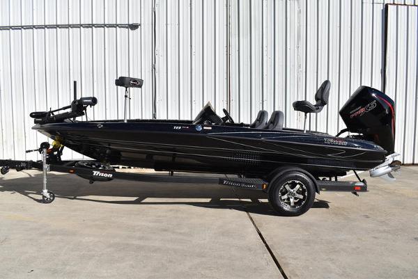 Slide: The Image of 2024 Triton 18 TrX bass boat on trailer, black exterior, parked outdoors. - 19