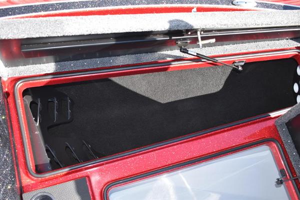 Slide: The Image of Open storage compartment of 2024 Triton 18 TrX boat with red exterior. - 19