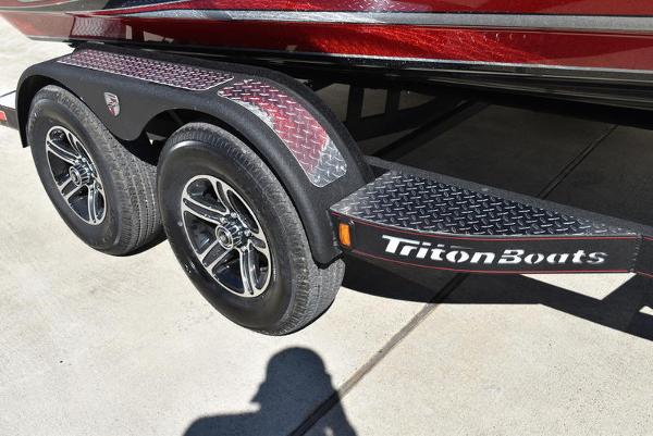 Slide: The Image of 2024 Triton 18 TrX boat trailer with dual wheels and TritonBoats branding. - 20
