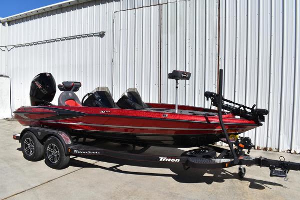 Slide: The Image of 2024 Triton 18 TrX bass boat in red on a trailer. - 27