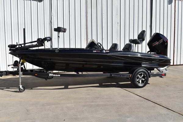 Slide: The Image of 2024 Triton 18 TrX bass boat on trailer, black exterior, side view. - 32