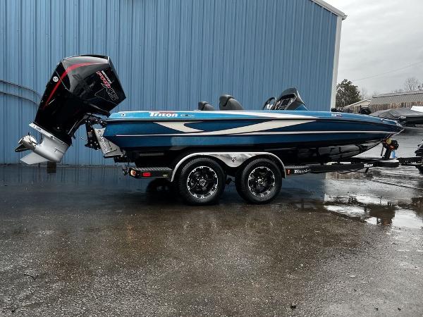 Slide: The Image of 2017 Triton 19 TrX boat with trailer, parked outside a blue building. - 0