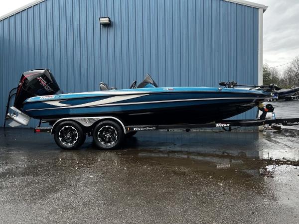 Slide: The Image of 2017 Triton 19 TrX boat on trailer, parked by blue building. - 1
