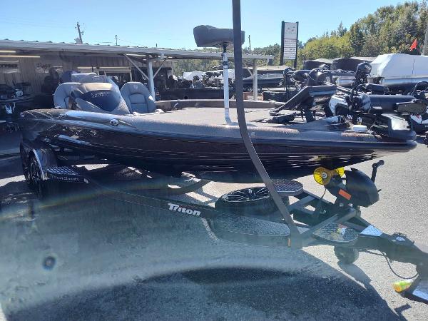 Slide: The Image of 2024 Triton 21 TrX bass boat on trailer in outdoor dealership. - 7