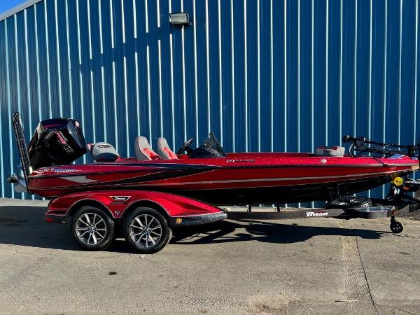 Slide: The Image of 2023 Triton 21 TrX Patriot bass boat in red on a trailer. - 1