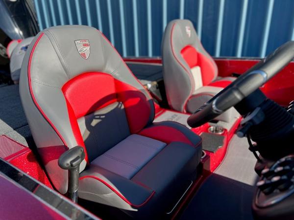 Slide: The Image of 2023 Triton 21 TrX Patriot boat interior with red and gray seats. - 2
