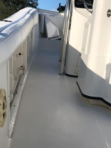 Slide: The Image of 2004 Triton 2690 CC boat interior, clean white deck and seating area. - 1