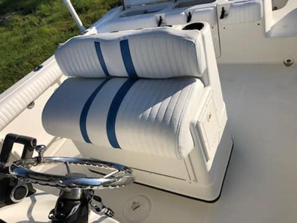 Slide: The Image of 2004 Triton 2690 CC boat interior with white and blue seating. - 8