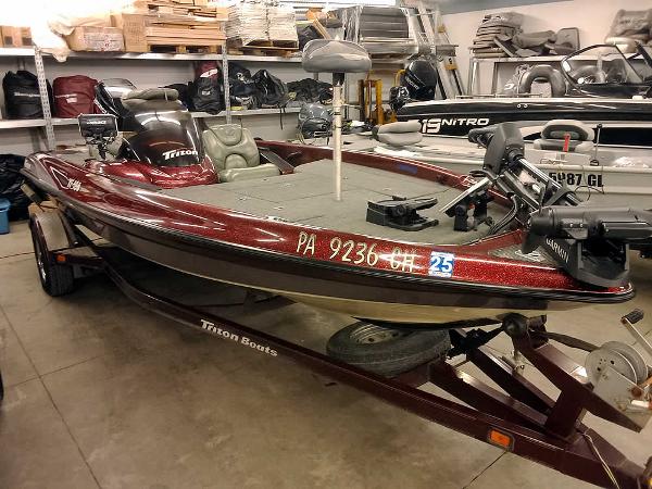 Slide: The Image of 2001 Triton TR186 SC bass boat in a garage, maroon color, on a trailer. - 32