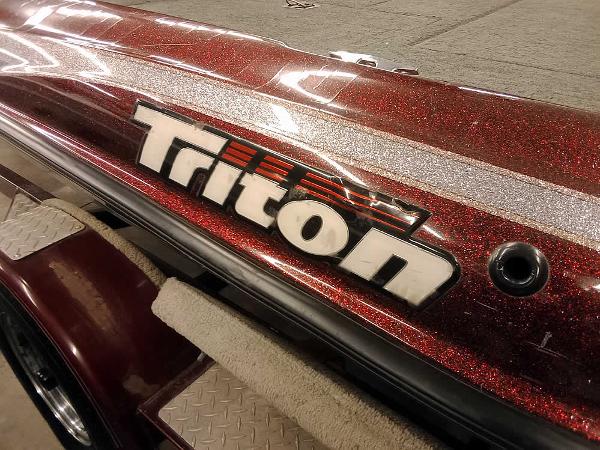 Slide: The Image of 2001 Triton TR186 SC boat with metallic red finish and logo detail. - 9