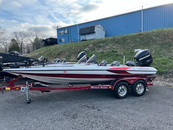 Slide: The Image of 1999 Triton TR20 boat on trailer with Mercury engine, parked outdoors. - 1
