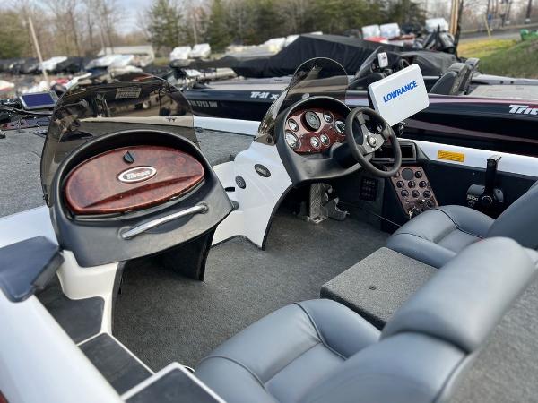 Slide: The Image of 1999 Triton TR20 boat interior with steering wheel and Lowrance electronics. - 2