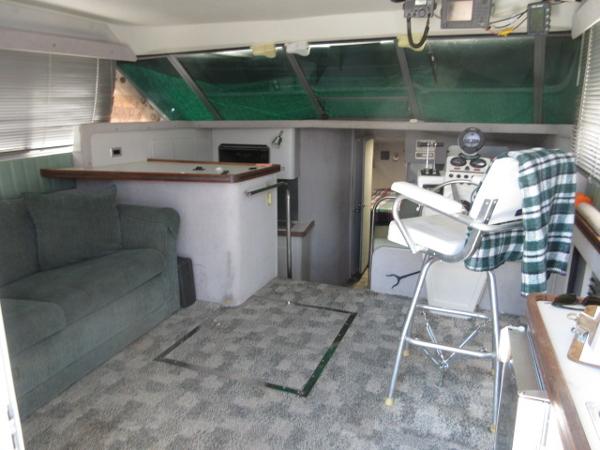 Slide: The Image of Interior of a 1986 Trojan 11 Meter Convertible boat with seating and control area. - 12