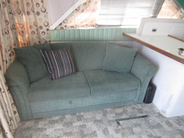 Slide: The Image of 1986 Trojan 11 Meter Convertible interior with green sofa and striped pillow. - 16