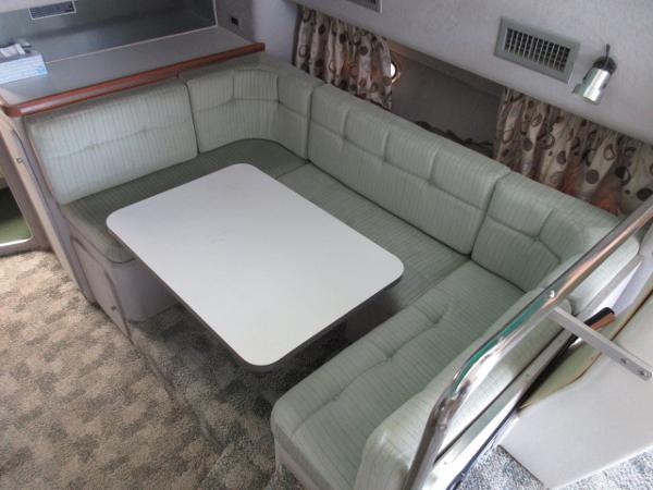 Slide: The Image of 1986 Trojan 11 Meter Convertible interior with L-shaped seating and dining table. - 17