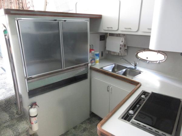 Slide: The Image of 1986 Trojan 11 Meter Convertible yacht kitchen with stainless steel fridge, sink, and stove. - 19