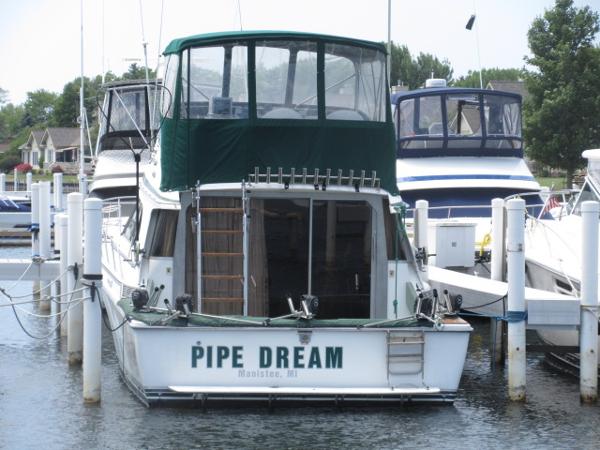 Slide: The Image of 1986 Trojan 11 Meter Convertible boat named Pipe Dream docked at a marina. - 2