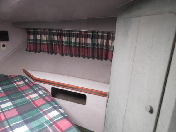 Slide: The Image of 1986 Trojan 11 Meter Convertible cabin interior with plaid bedding and striped curtains. - 27
