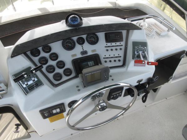 Slide: The Image of 1986 Trojan 11 Meter Convertible boat helm with gauges, controls, and navigation equipment. - 8