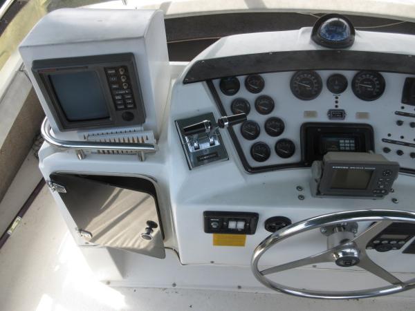 Slide: The Image of 1986 Trojan 11 Meter Convertible boat dashboard with steering wheel, gauges, and navigation equipment. - 9