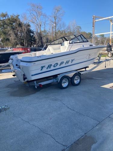 Slide: The Image of 1997 Trophy Bayliner Walk Around boat on a trailer in a marina. - 1