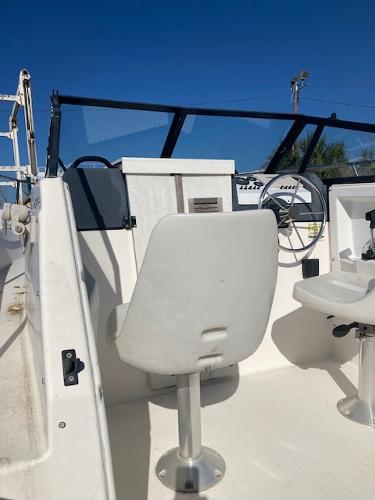 Slide: The Image of 1997 Trophy BAYLINER WALK AROUND boat cockpit with steering wheel and seating. - 6
