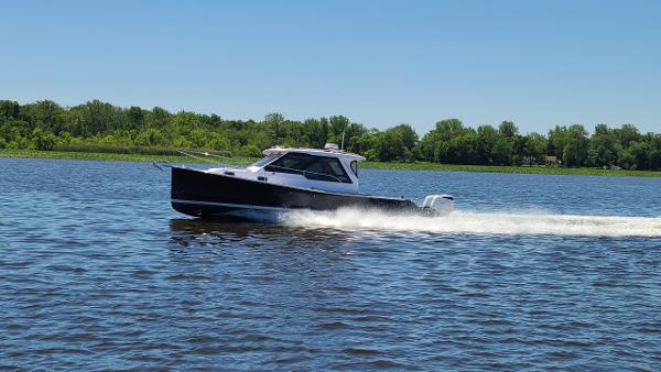 Slide: The Image of 2024 True North 34 boat cruising on a lake under clear blue skies. - 22