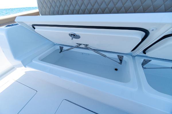 Slide: The Image of 2025 Valhalla Boatworks V-46 storage compartment with open lid and cushioned seating. - 14