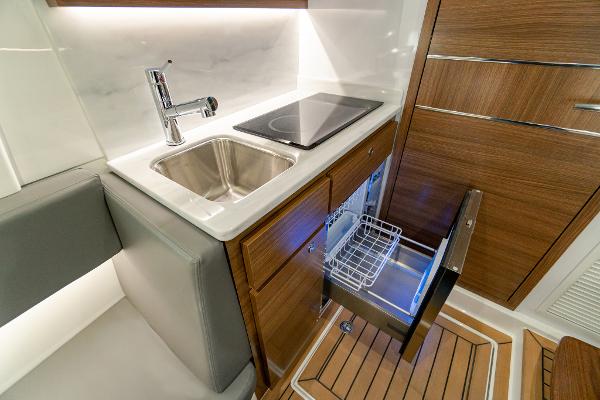 Slide: The Image of Modern kitchen area in 2025 Valhalla Boatworks V-46, featuring sink and induction cooktop. - 25