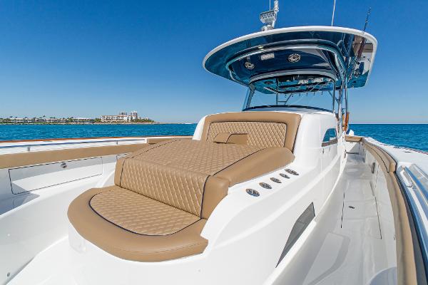 Slide: The Image of 2025 Valhalla Boatworks V-46 luxury boat with tan seating, cruising on clear blue water. - 34