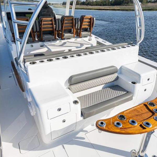 Slide: The Image of 2025 Valhalla Boatworks V-55 interior, featuring seating and rod holders, on a serene water backdrop. - 11