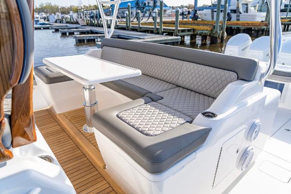 Slide: The Image of 2025 Valhalla Boatworks V-55 luxury seating area with table, docked at marina. - 4
