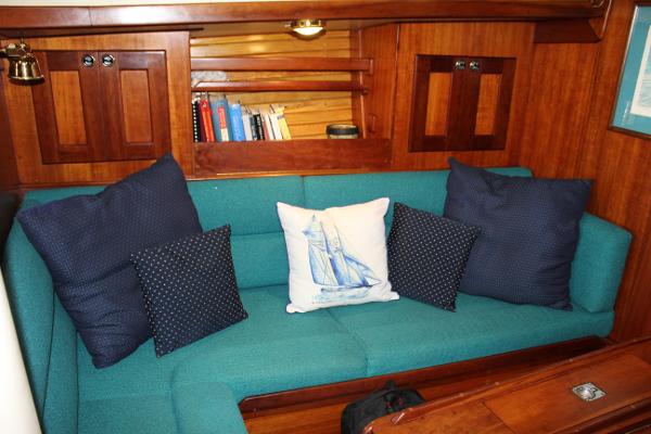Slide: The Image of Cozy Valiant 42 sailboat interior with teal sofa and nautical-themed pillows, 1996 model. - 32