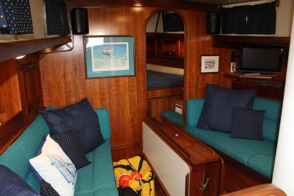 Slide: The Image of Interior of a 1996 Valiant 42 sailboat with teal seating and wooden finishes. - 35