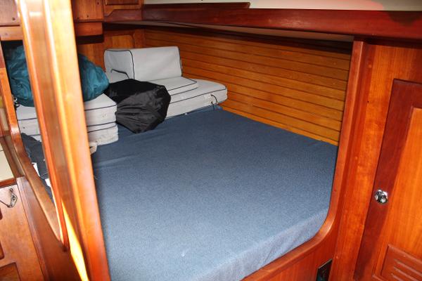 Slide: The Image of 1996 Valiant 42 boat cabin with wooden interior and blue bedding. - 41