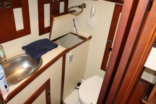 Slide: The Image of 1996 Valiant 42 boat bathroom with sink, toilet, and wooden cabinetry. - 44