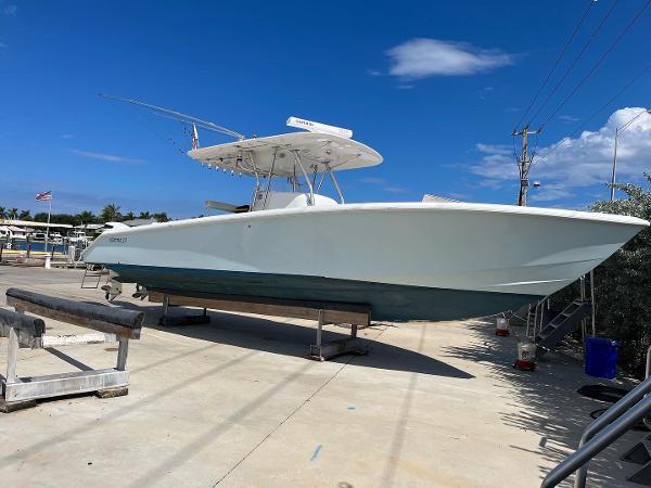 Slide: The Image of 2004 Venture 34 Center Console boat on a dry dock under a clear blue sky. - 1