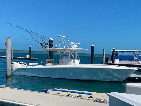 Slide: The Image of 2004 Venture 34 Center Console boat docked at a marina on a sunny day. - 2